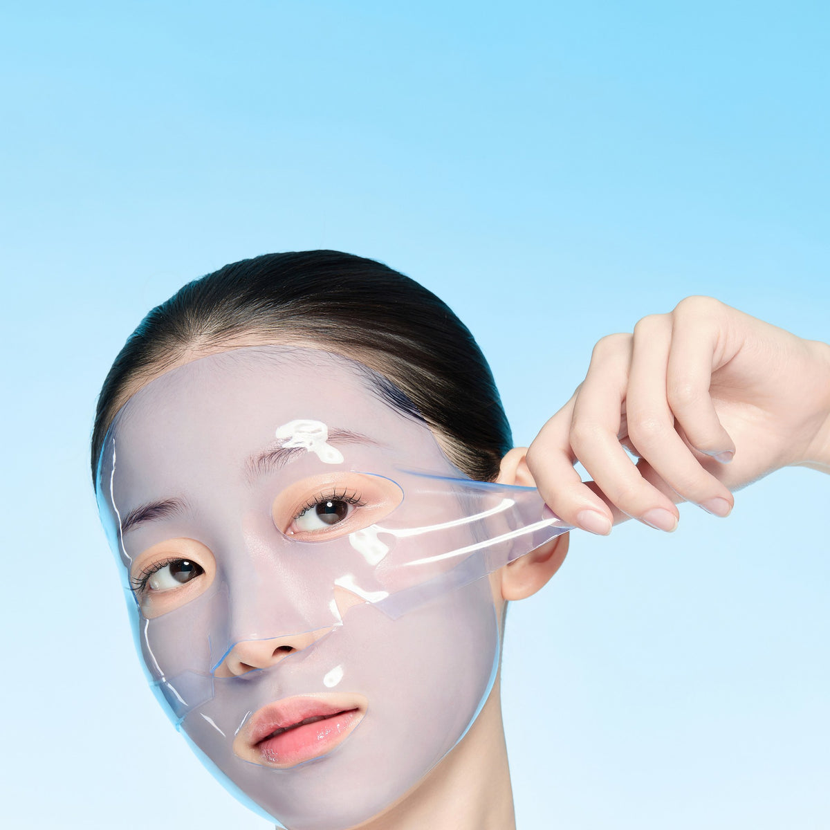Modelo retirando la mascarilla hidrogel Azulene Cica Calming Mask de from medi+, ya transparente