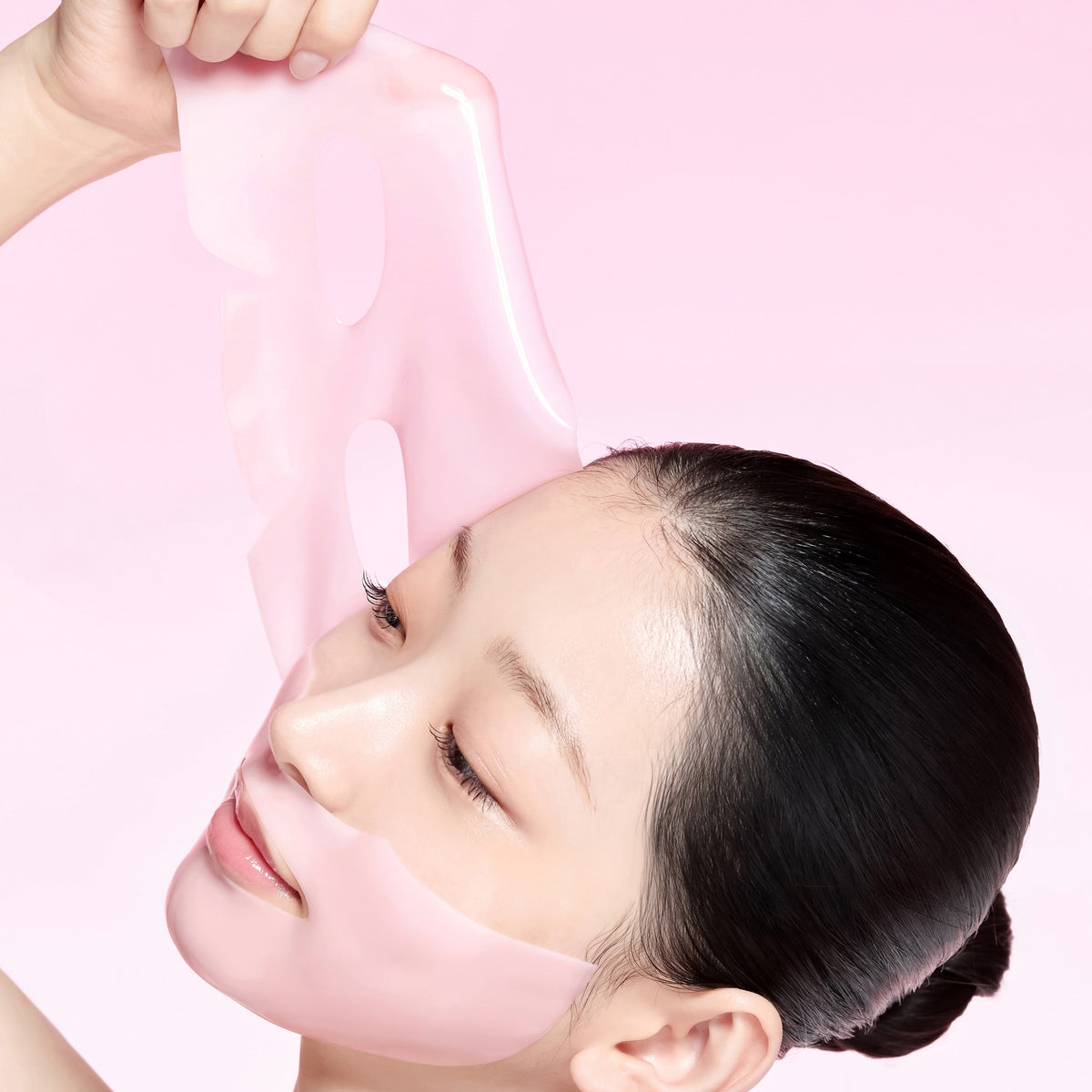 Modelo retirando la mascarilla hidrogel rosa TXA Niacinamide Brightening Mask de from medi+